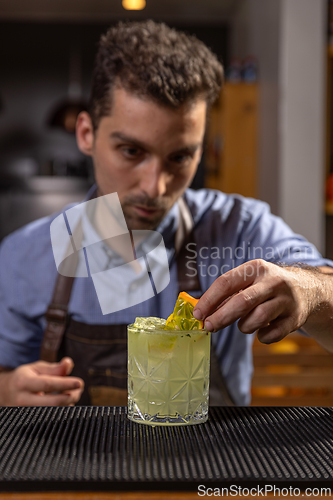 Image of Bartender garnishing a cocktail with kiwano