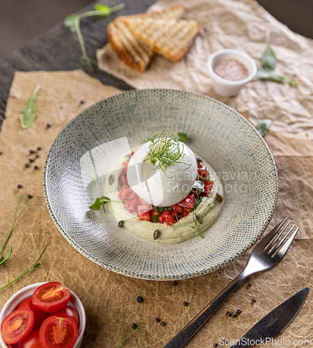 Image of Burrata cheese resting on hummus
