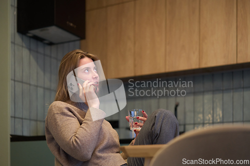 Image of Phone Call at the Table with a Thoughtful Expression