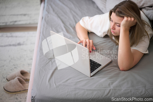 Image of Quiet Bedside Browsing in Soft Gray Bedding