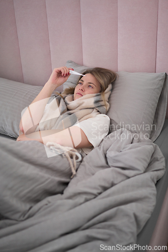 Image of Resting While Checking Thermometer on a Sick Day