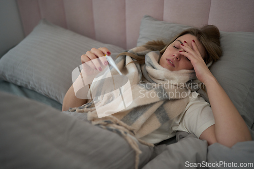 Image of Unwell Morning Checking Temperature in Bed