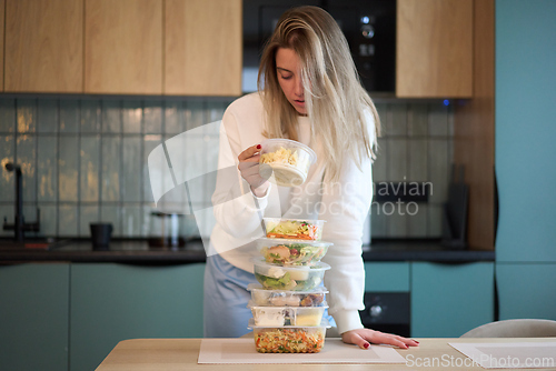 Image of Inspecting a Meal Container Over a Tall Food Stack