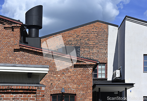 Image of modern brick and concrete building with black vent pipe 