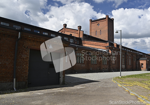Image of A historic brick industrial building with large arched windows a