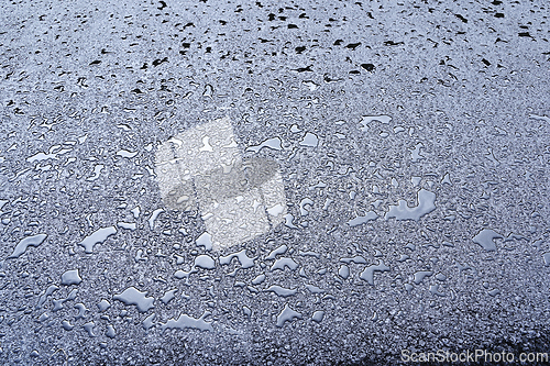 Image of A close-up view of wet pavement covered in water droplets