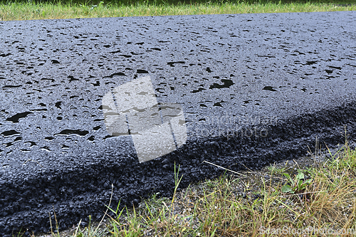 Image of A close-up view of wet pavement covered in water droplets