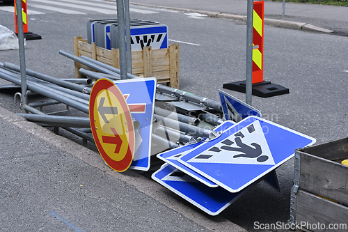 Image of A collection of road signs and metal poles placed on the side of