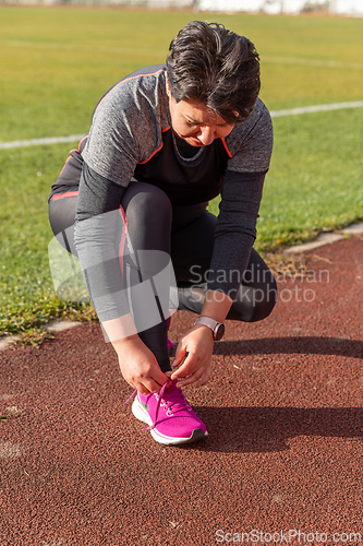 Image of Woman tying shoelaces