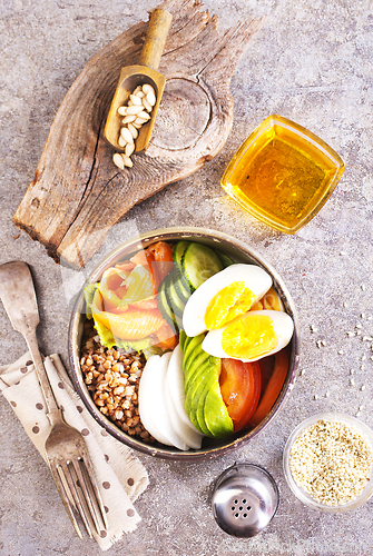 Image of Healthy vegan nutritious bowl with buckwheat. Salad of avocado, salmon, buckwheat, egg and tomato