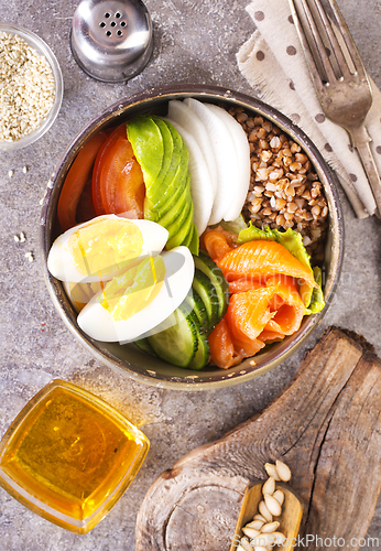 Image of Healthy vegan nutritious bowl with buckwheat. Salad of avocado, salmon, buckwheat, egg and tomato