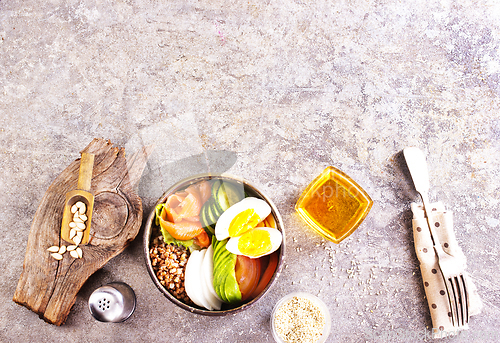 Image of Healthy vegan nutritious bowl with buckwheat. Salad of avocado, salmon, buckwheat, egg and tomato