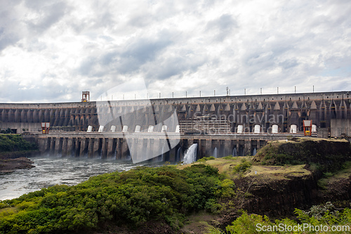 Image of Long concrete wall and multiple turbine outlets on the Parana River border shared by two nations. Itaipu Binacional, Brazil