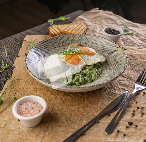 Image of Plate of fried eggs on green peas puree