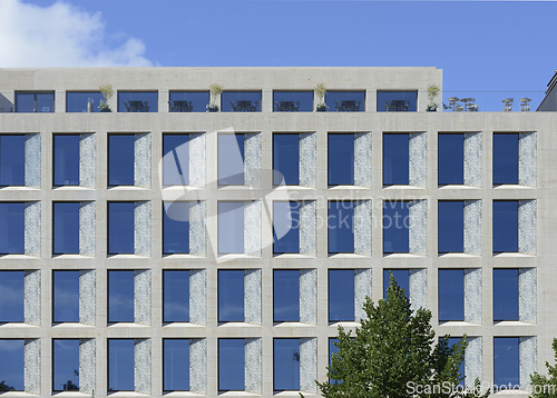 Image of A modern office building featuring a symmetrical facade with lar