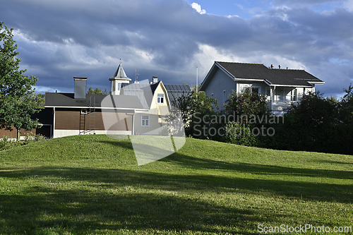 Image of a serene residential area with wooden, yellow, and gray houses, 