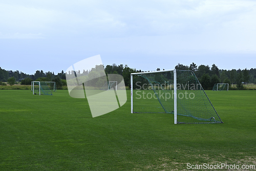 Image of An empty soccer field with multiple goalposts set against 