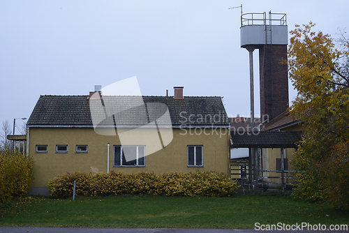 Image of yellow single-story building with a tile roof and small, rectang