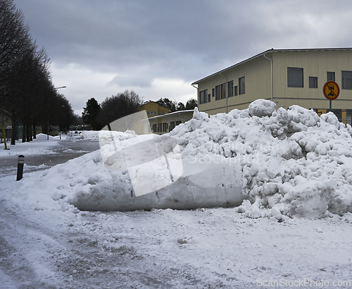 Image of a substantial pile of snow accumulated in a suburban area during