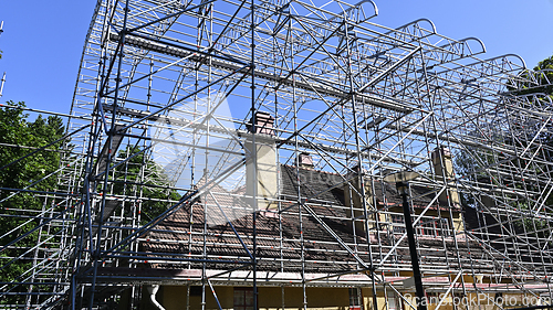Image of A house undergoing renovation is surrounded by an extensive scaf