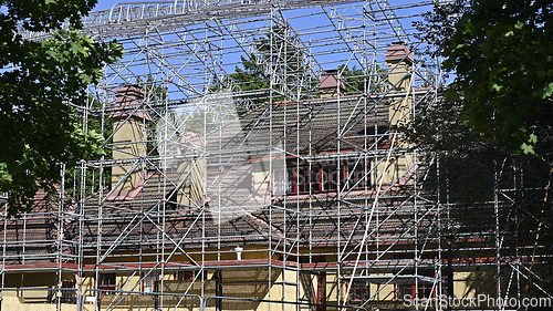 Image of A house undergoing renovation is surrounded by an extensive scaf