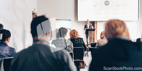 Image of Speaker giving a talk in conference hall at business event. Rear view of unrecognizable people in audience at the conference hall. Business and entrepreneurship concept.