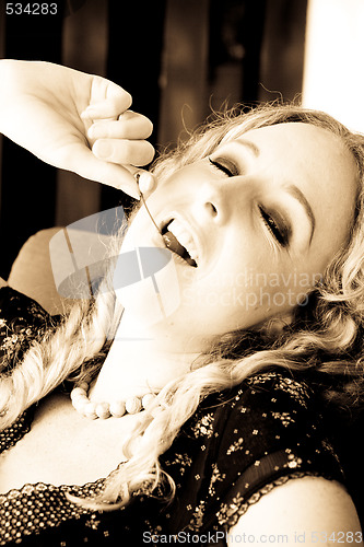 Image of Woman eating a cherry.