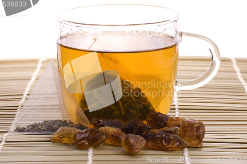 Image of white tea, nylon tea-bag and golden sugar