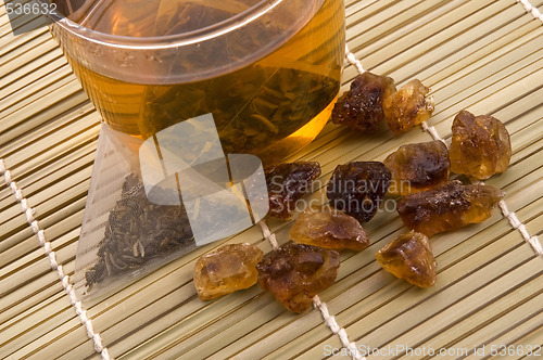 Image of white tea, nylon tea-bag and golden sugar