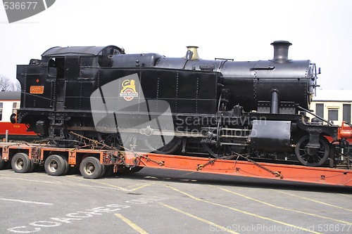 Image of black steam locomotive on  a transporter