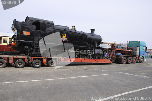 Image of black steam locomotive on  a transporter