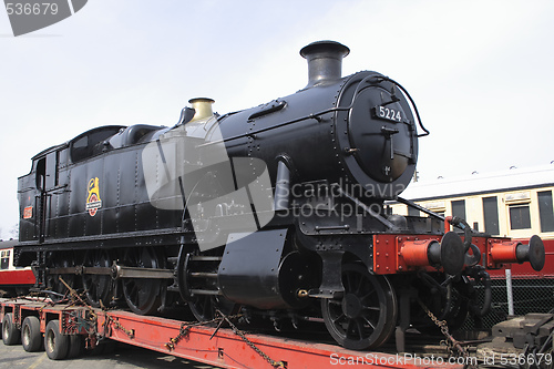 Image of black steam locomotive on  a transporter