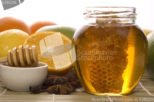 Image of fresh honey with honeycomb, spices and fruits