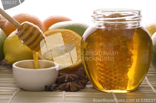 Image of fresh honey with honeycomb, spices and fruits