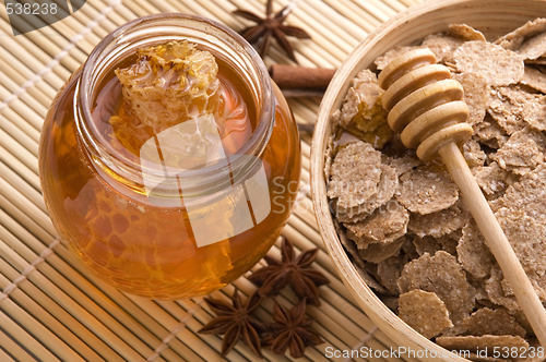 Image of fresh honey with honeycomb, spices and breakfast flakes