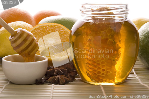 Image of fresh honey with honeycomb, spices and fruits