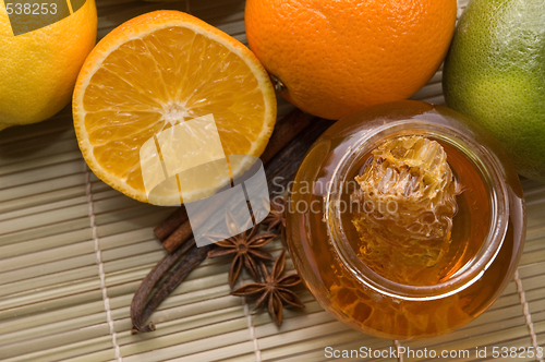 Image of fresh honey with honeycomb, spices and fruits