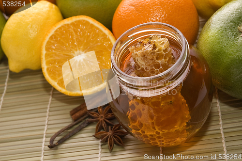 Image of fresh honey with honeycomb, spices and fruits