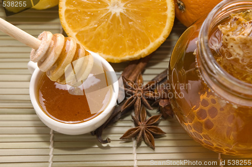 Image of fresh honey with honeycomb, spices and fruits