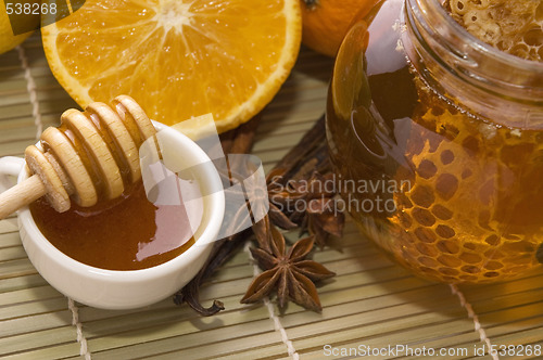 Image of fresh honey with honeycomb, spices and fruits