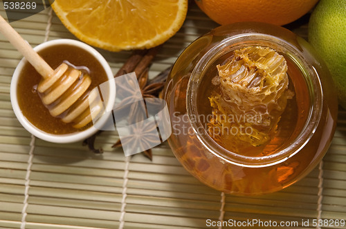 Image of fresh honey with honeycomb, spices and fruits