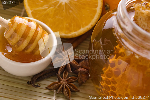 Image of fresh honey with honeycomb, spices and fruits