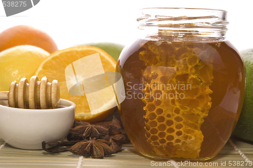 Image of fresh honey with honeycomb, spices and fruits