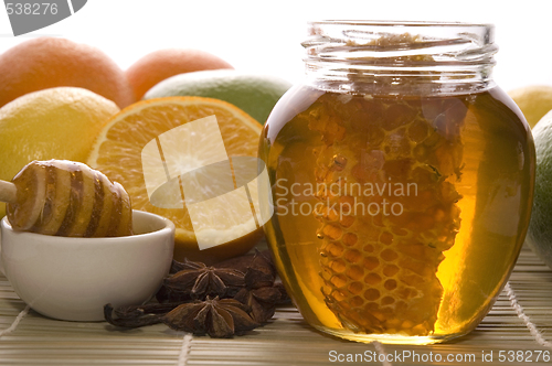 Image of fresh honey with honeycomb, spices and fruits