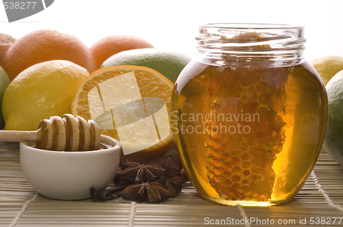 Image of fresh honey with honeycomb, spices and fruits