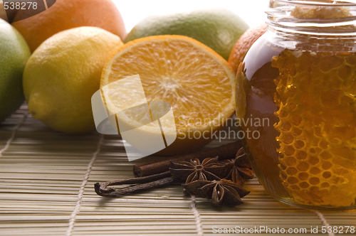 Image of fresh honey with honeycomb, spices and fruits