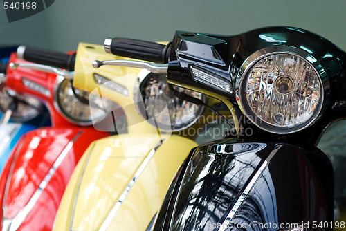 Image of Three scooters, black, yellow and red
