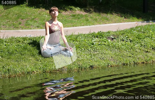 Image of girl meditating near by water
