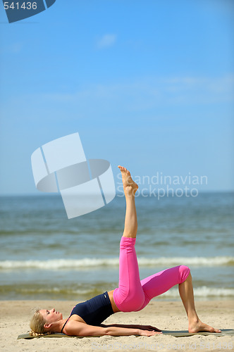 Image of Sporty female workout on the beach