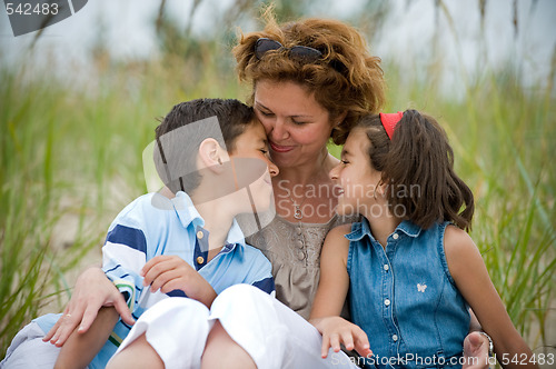 Image of happy mother and kids on the beach
